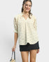 Woman wearing a cream lace blouse and black skirt on a white background