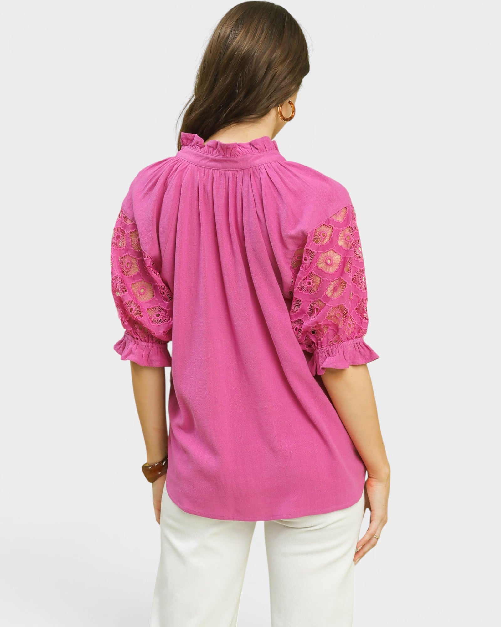 Pink blouse with lace details on a white background