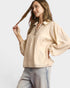 Woman wearing a beige blouse with leopard print details on a white background