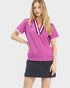 Woman wearing a pink polo shirt with a navy skirt on a white background