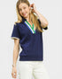 Woman wearing a navy blue polo shirt with a colorful collar on a white background