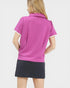 Woman wearing a pink polo shirt and black skirt on a white background