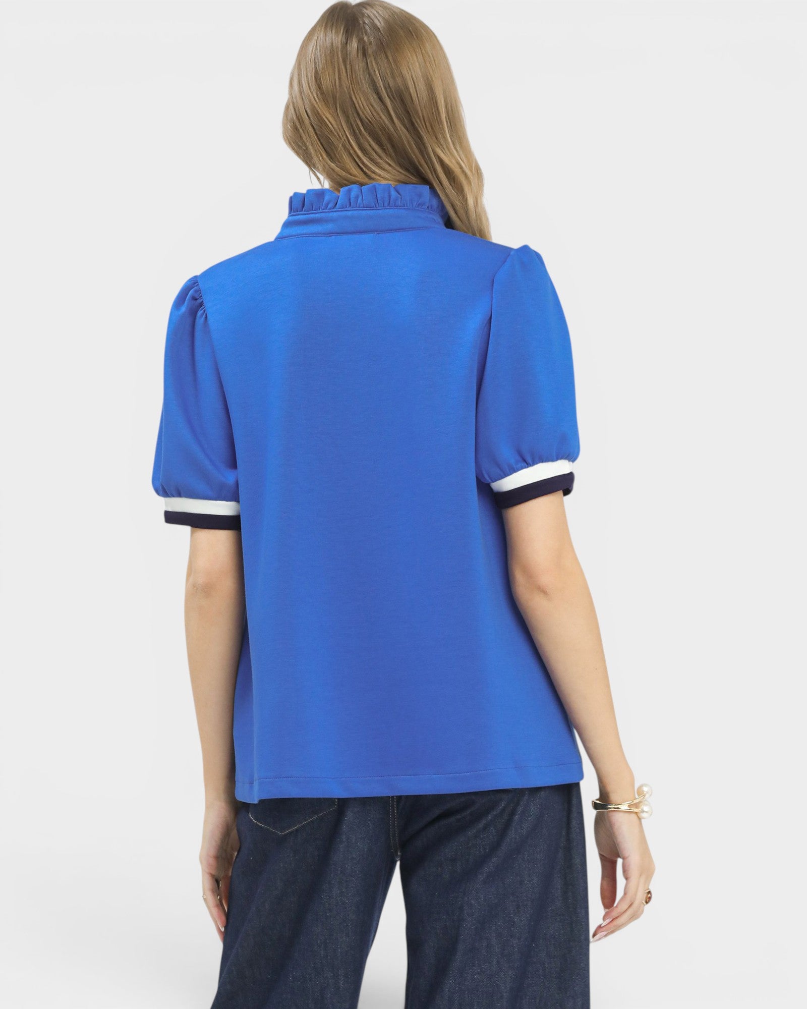 Person wearing a blue polo shirt with white trim on a white background