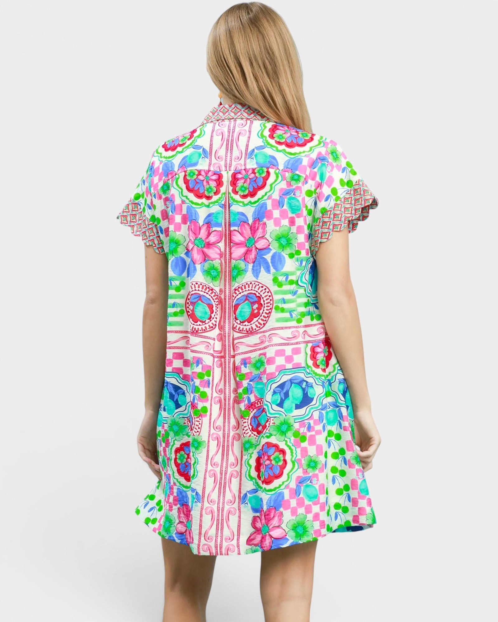 Woman wearing a colorful patterned dress on a white background