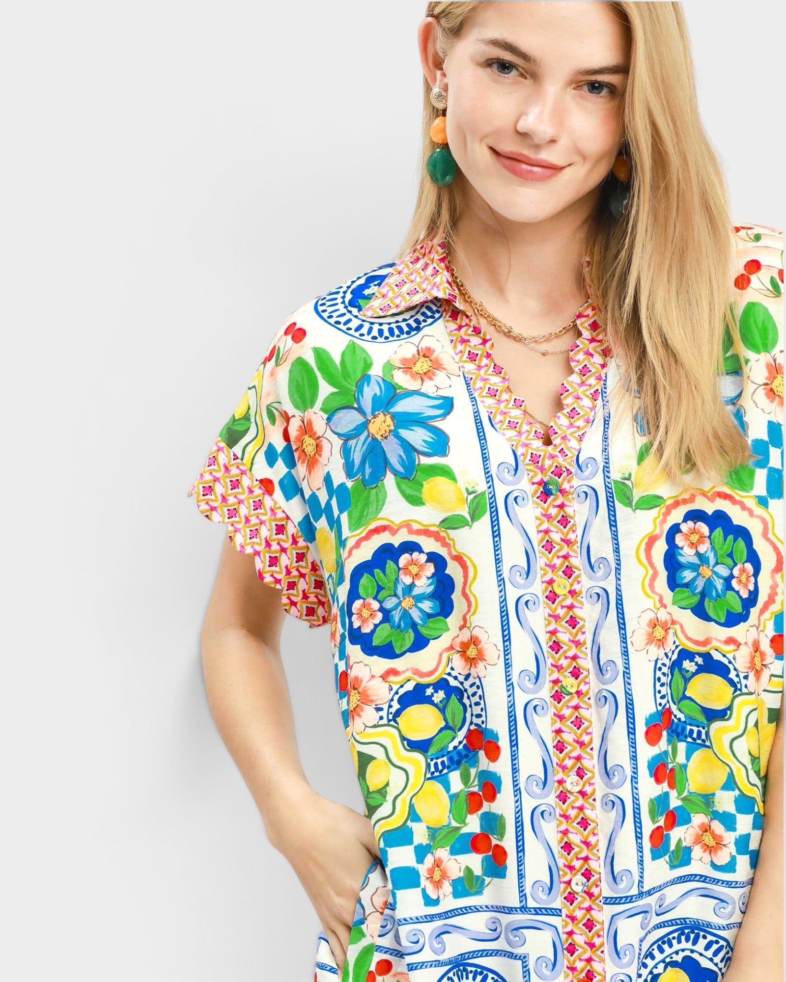 Woman wearing a colorful floral and patterned shirt on a white background