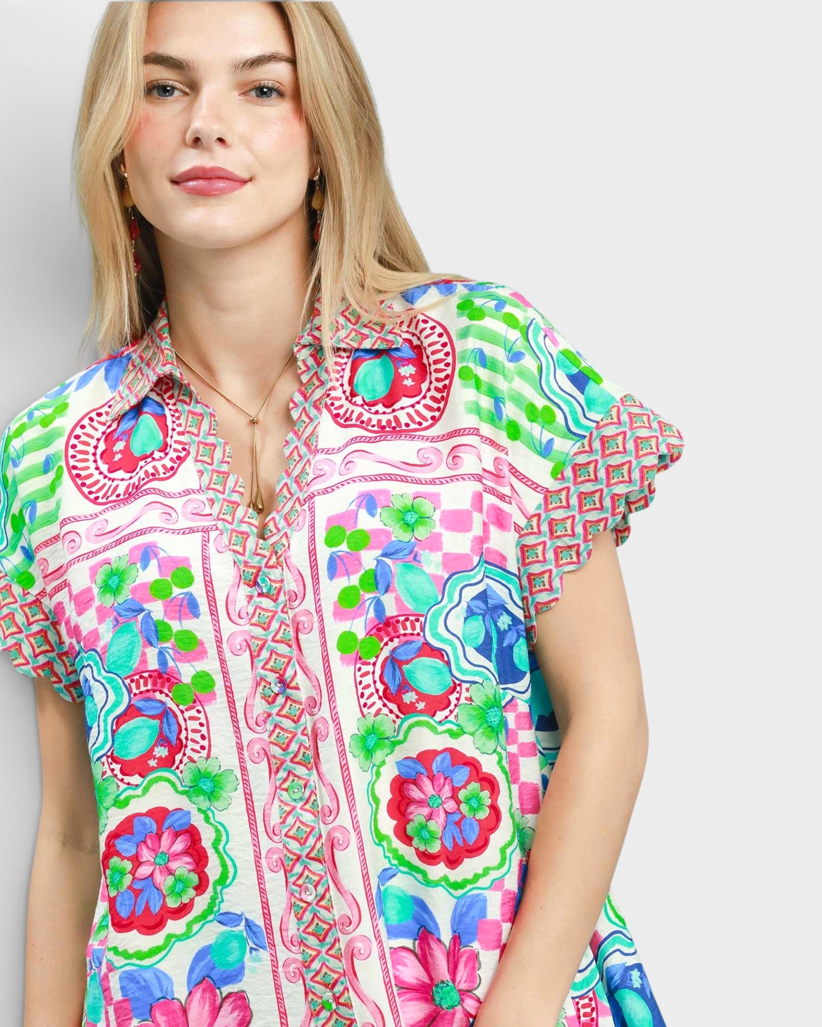 Woman wearing a colorful patterned shirt on a plain background