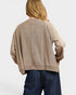 Person wearing a beige sweater and blue jeans on a white background