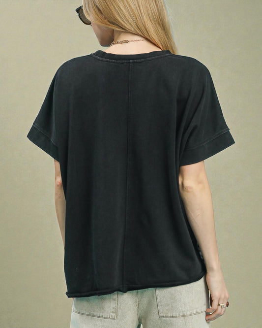 Person wearing a black t-shirt from behind on a beige background