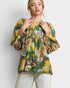 Woman wearing a colorful floral blouse against a white background