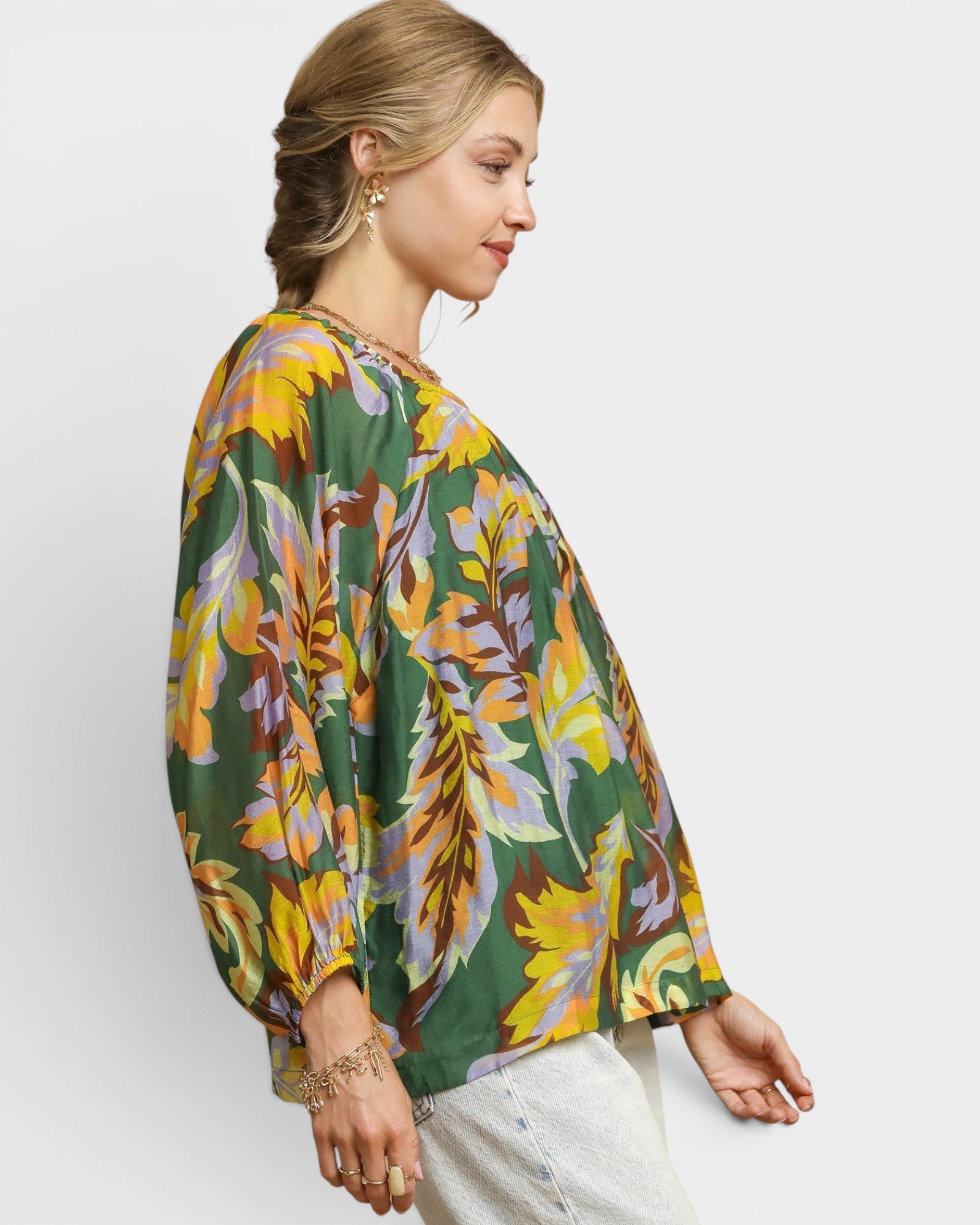 Woman wearing a colorful floral blouse against a white background