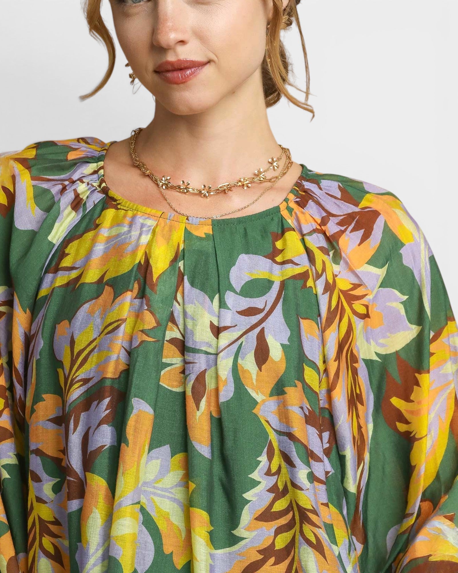 Woman wearing a colorful floral dress with a neutral background