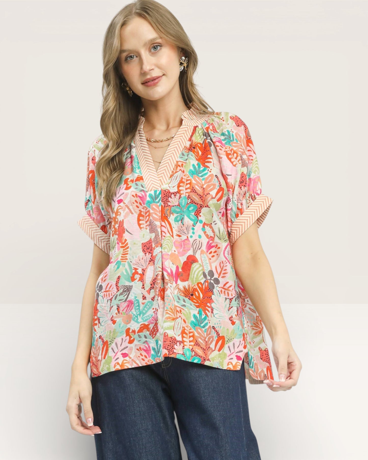 Woman wearing a colorful floral blouse with a plain background
