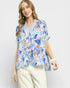 Woman wearing a colorful floral blouse with a white background