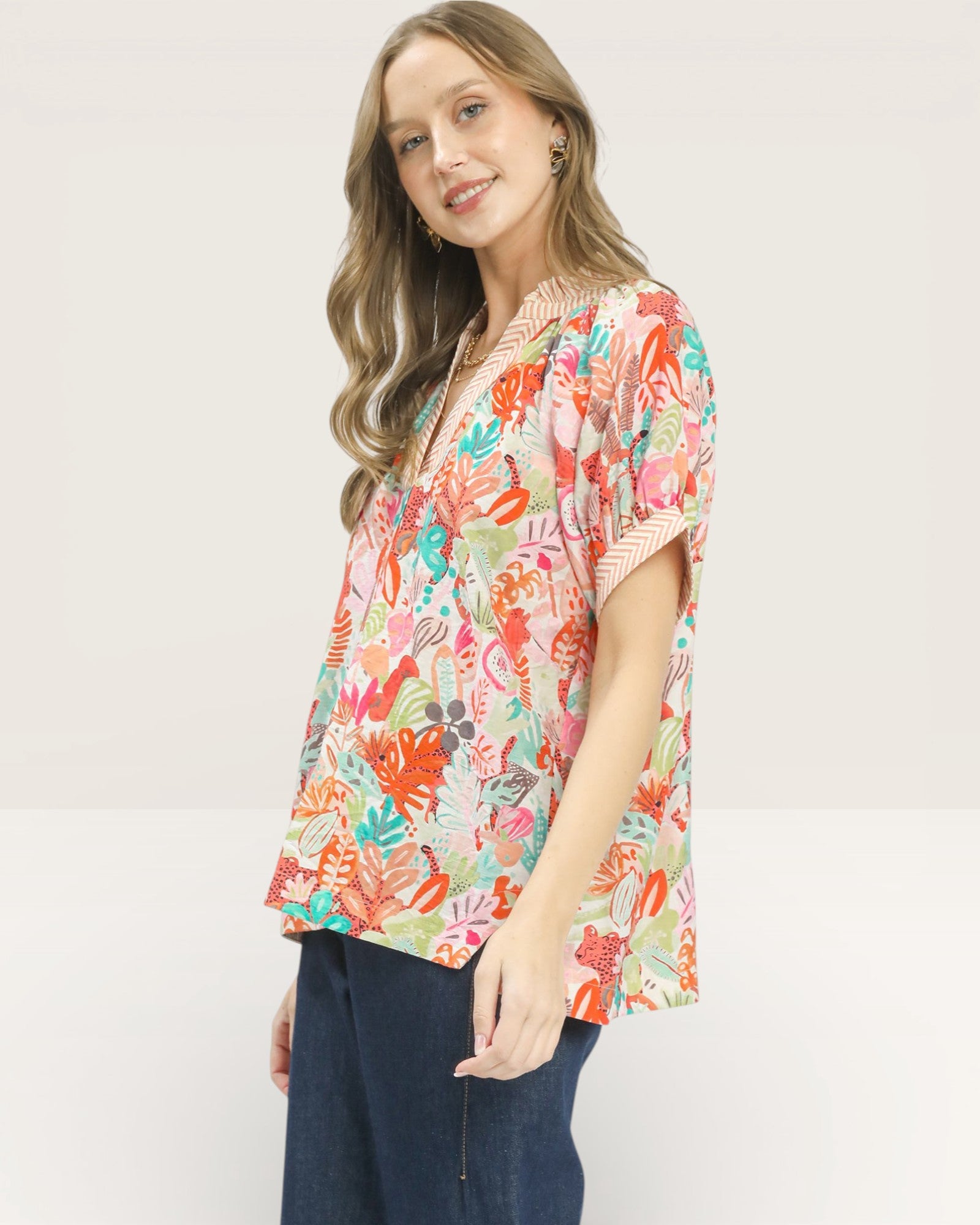Woman wearing a colorful floral blouse on a white background