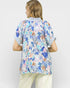 Person wearing a colorful patterned shirt with a white background