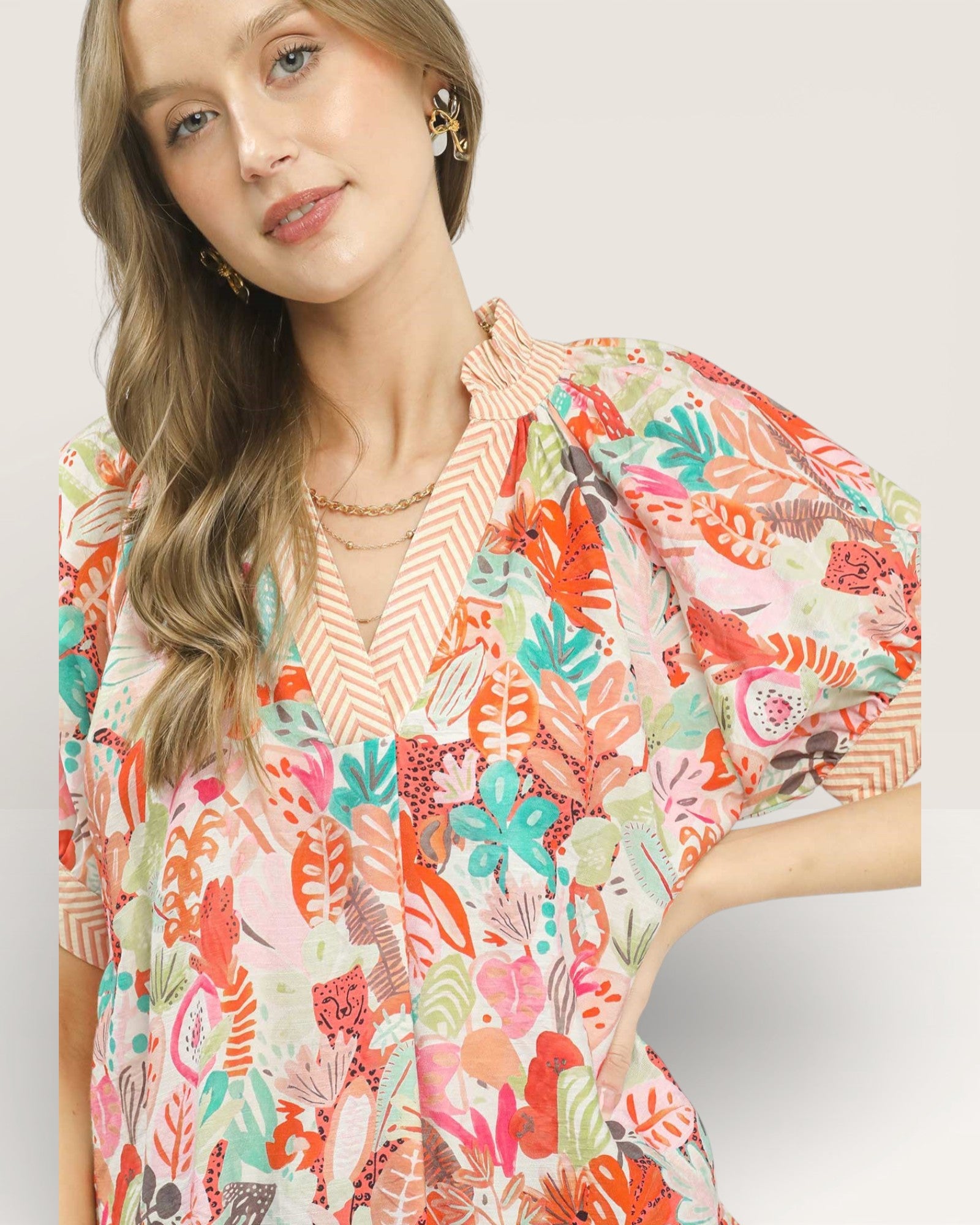 Woman wearing a colorful floral blouse on a white background
