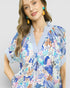 Woman wearing a colorful floral dress with a white background