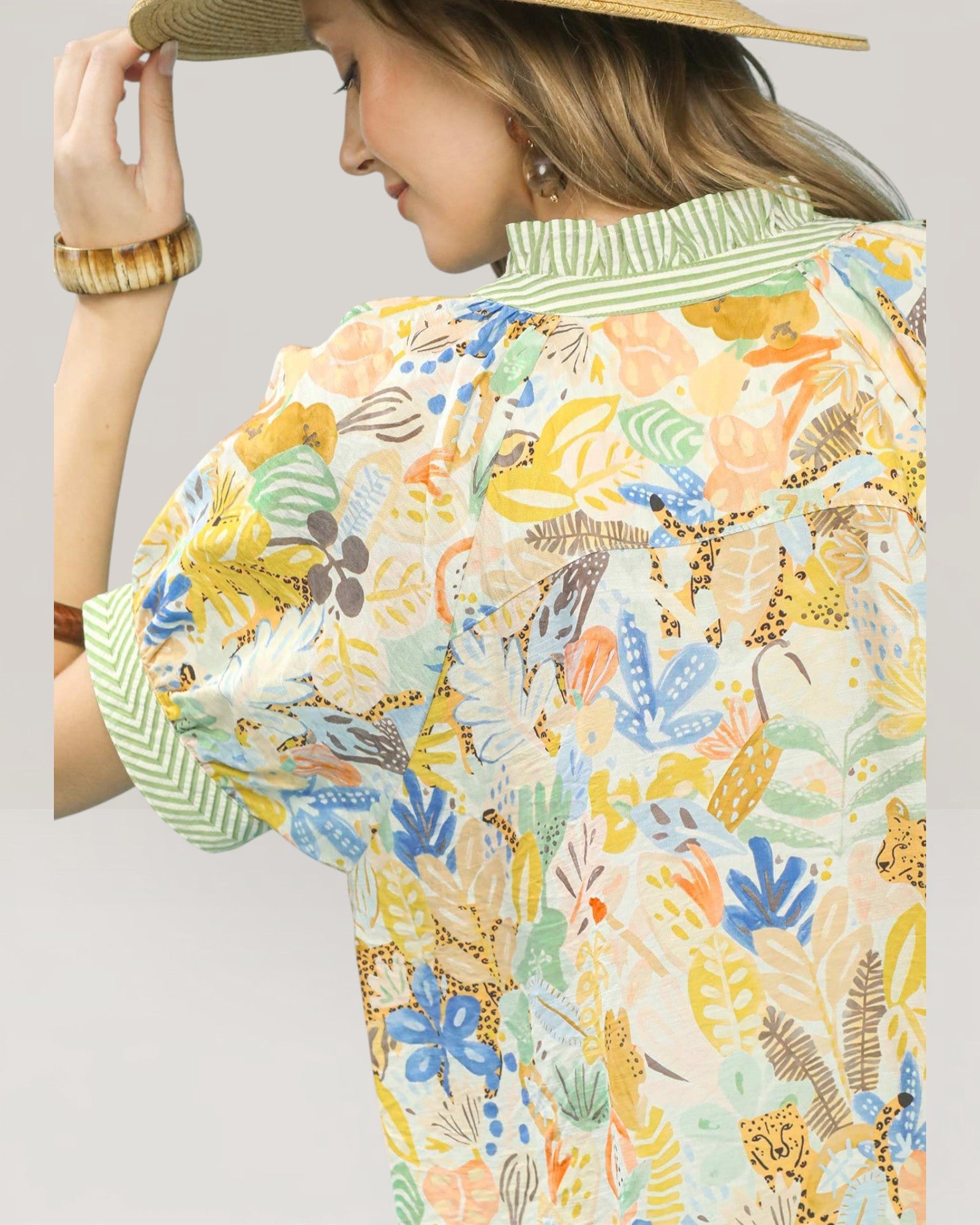 Woman wearing a colorful floral shirt with a neutral background