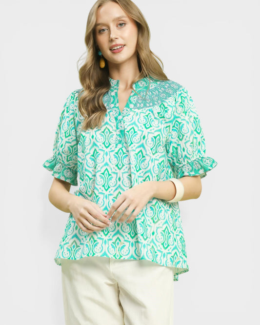 Woman wearing a green patterned blouse on a white background