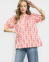 Woman wearing a colorful patterned blouse and jeans on a white background