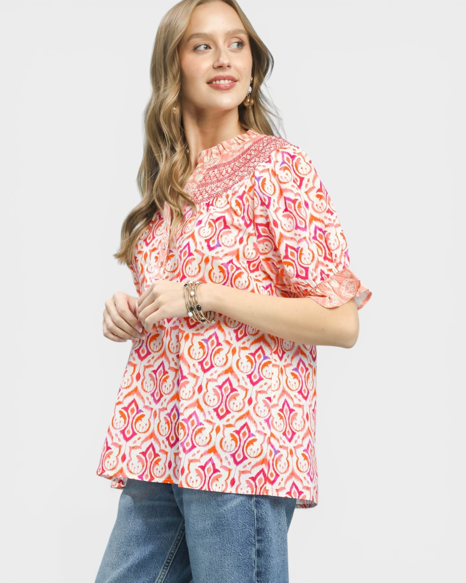 Woman wearing a colorful patterned blouse on a white background