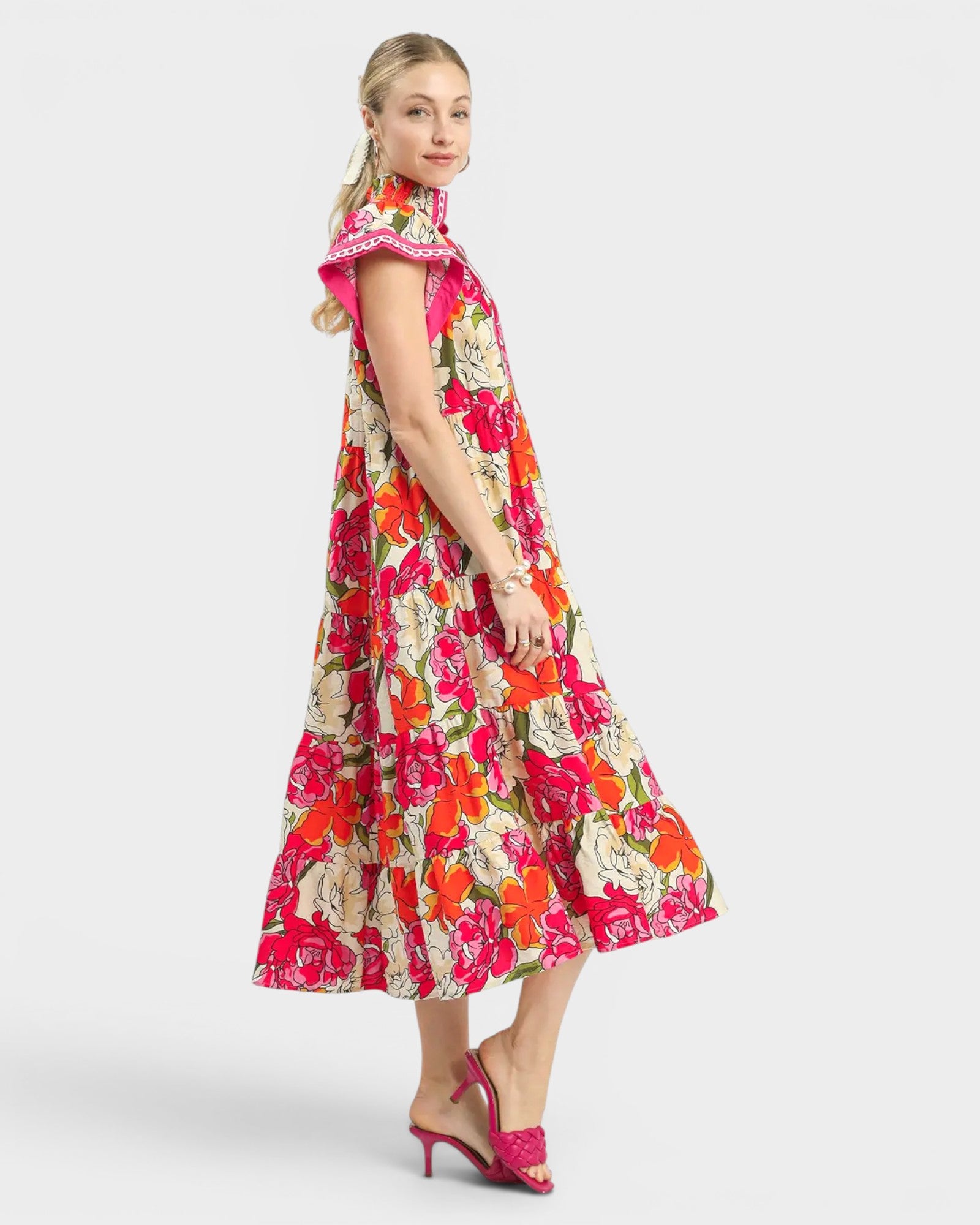 Woman wearing a colorful floral dress on a white background