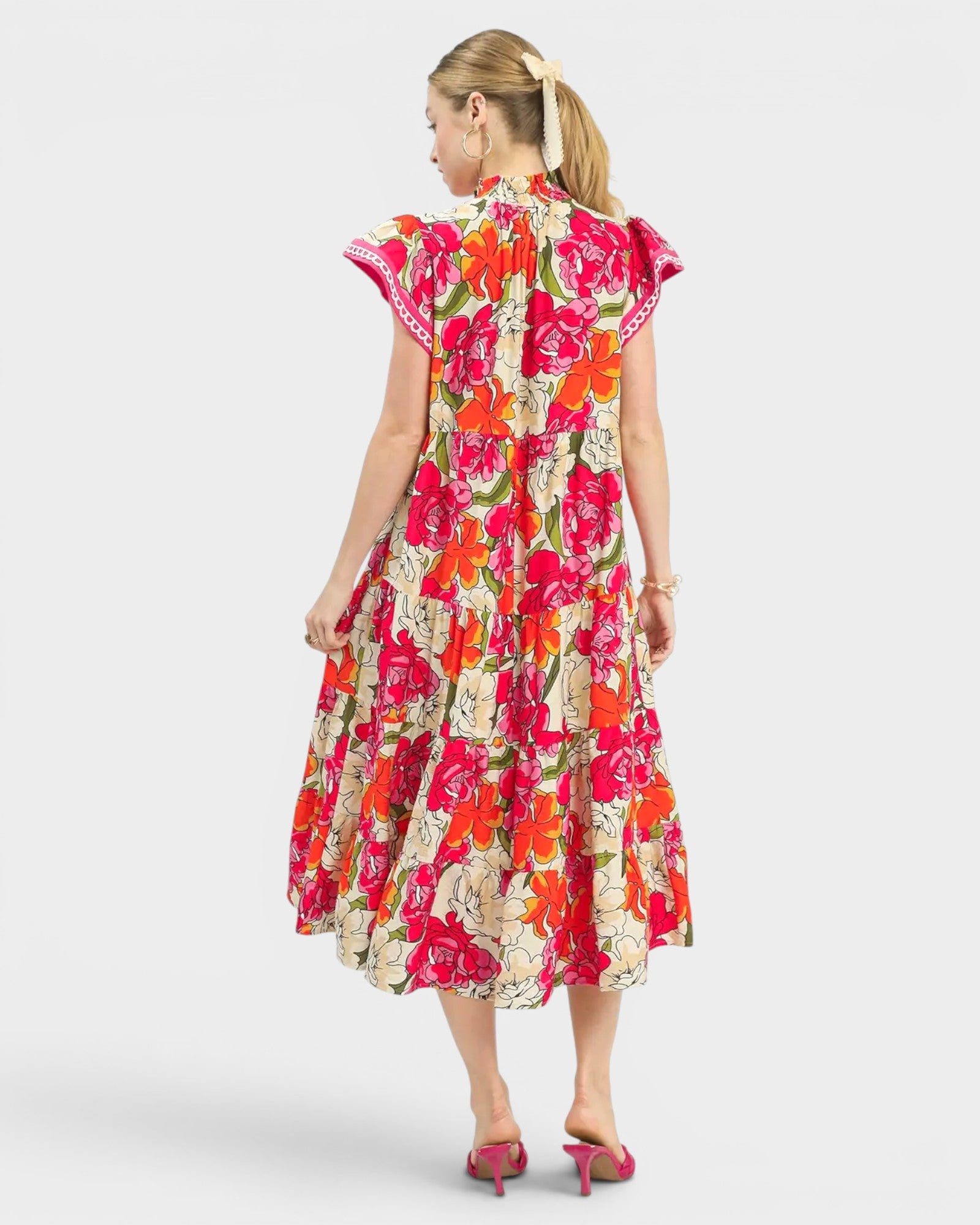 Woman wearing a colorful floral dress on a white background