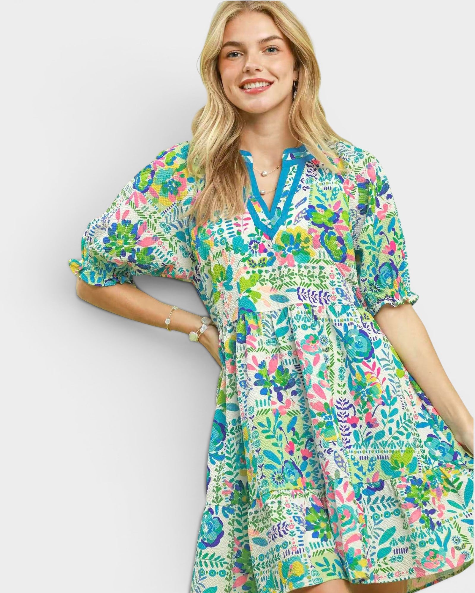 Woman wearing a colorful floral dress on a plain background