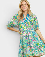 Woman wearing a colorful floral dress on a plain background
