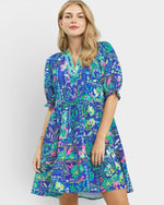 Woman wearing a colorful floral dress on a white background