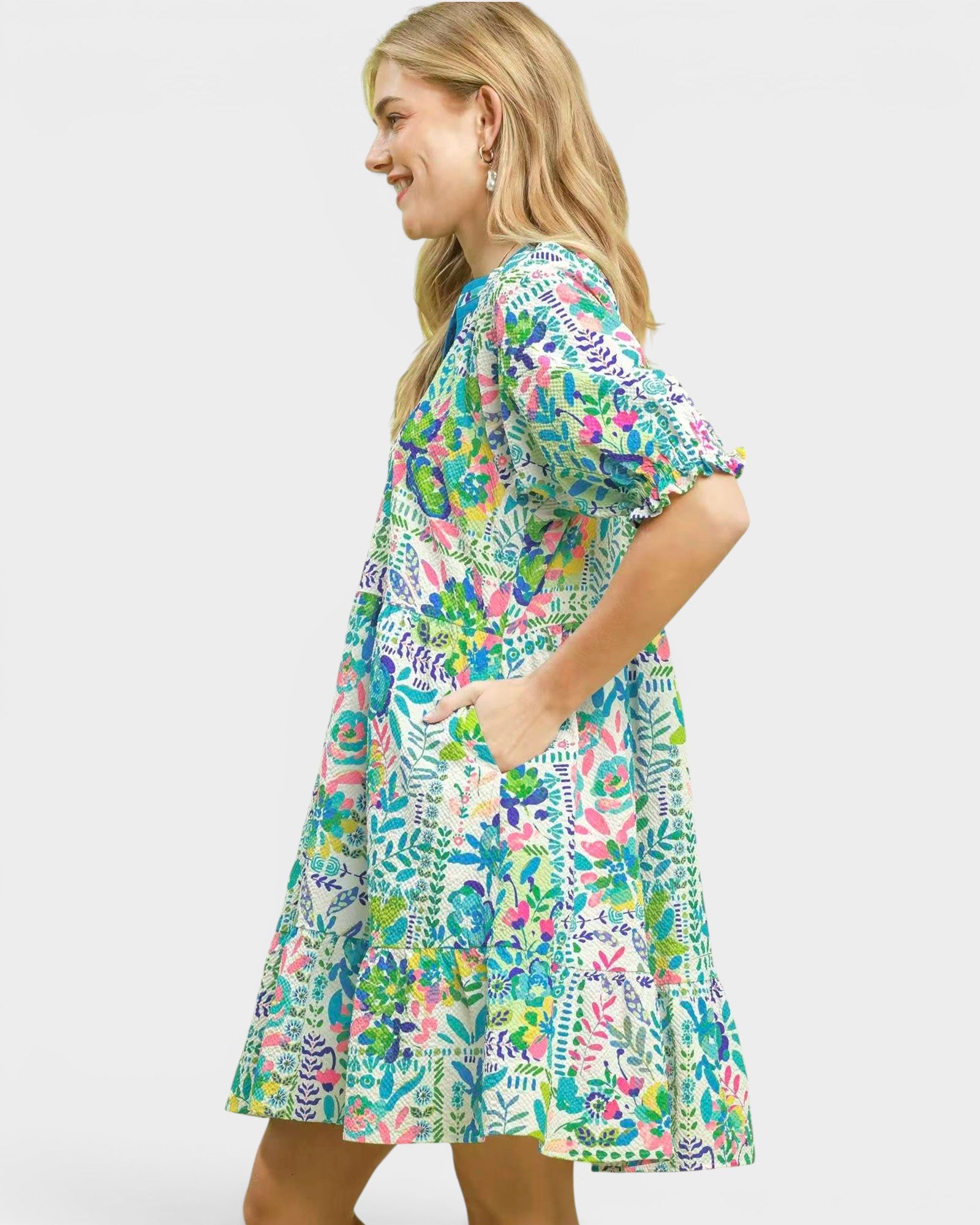 Woman wearing a colorful floral dress on a white background