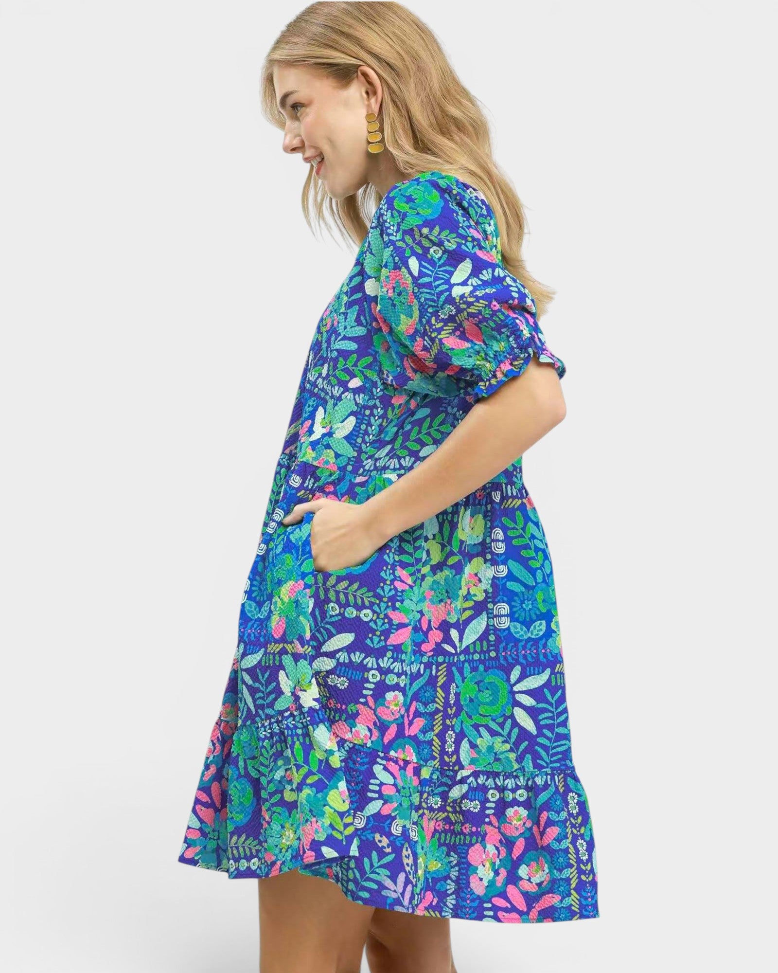 Woman wearing a colorful floral dress on a white background