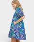 Woman wearing a colorful floral dress on a white background