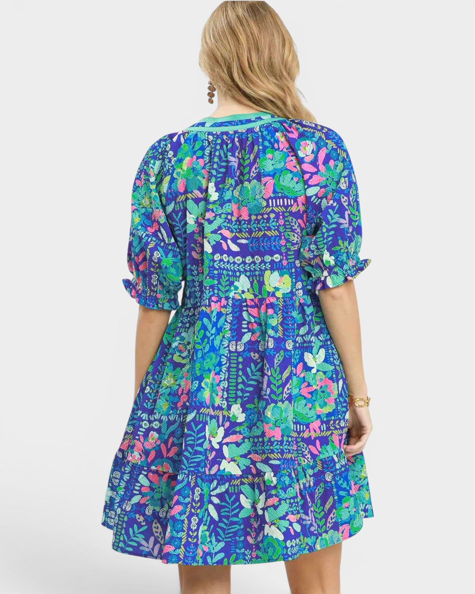Woman wearing a colorful floral dress on a white background
