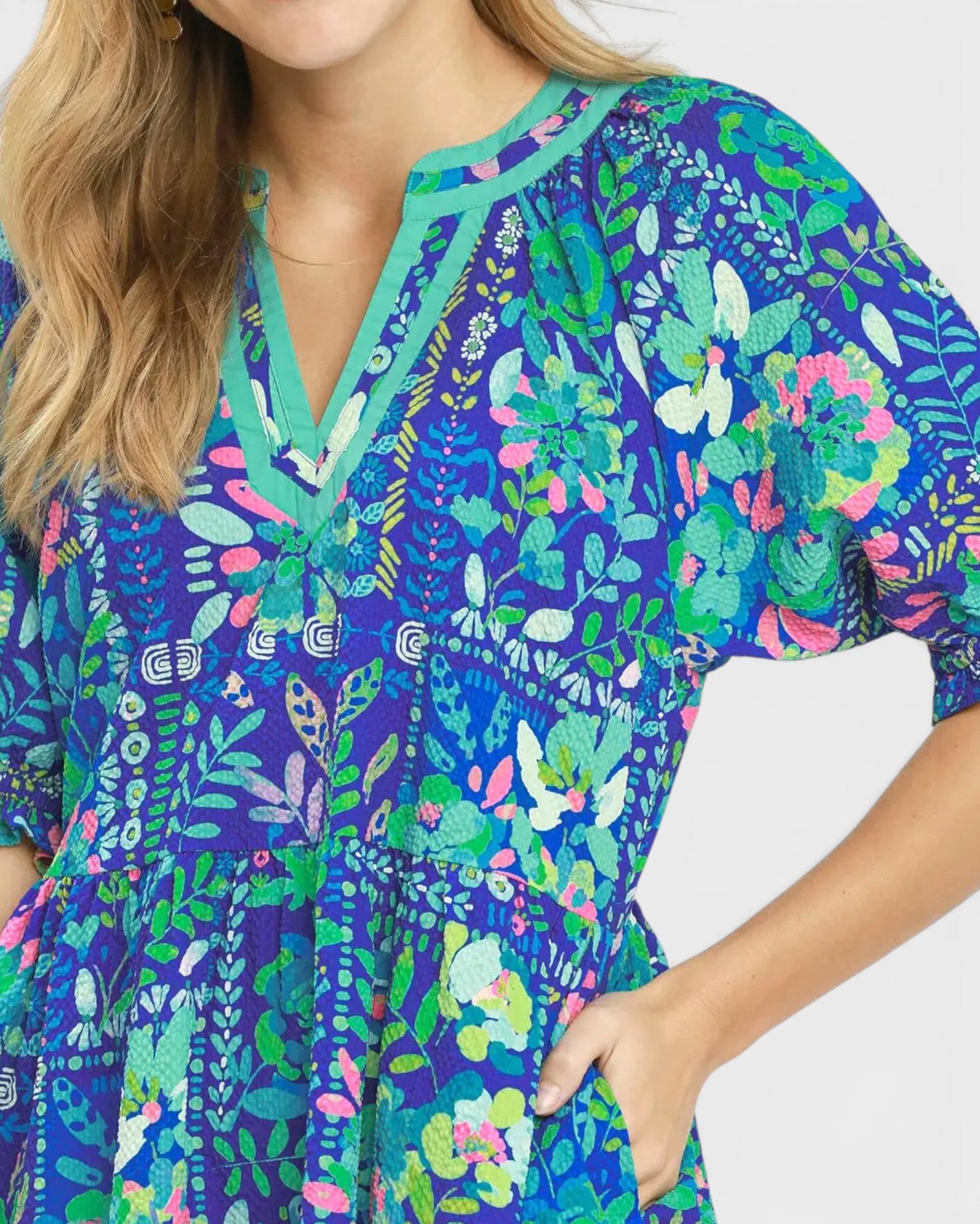 Woman wearing a colorful floral dress with a blue background