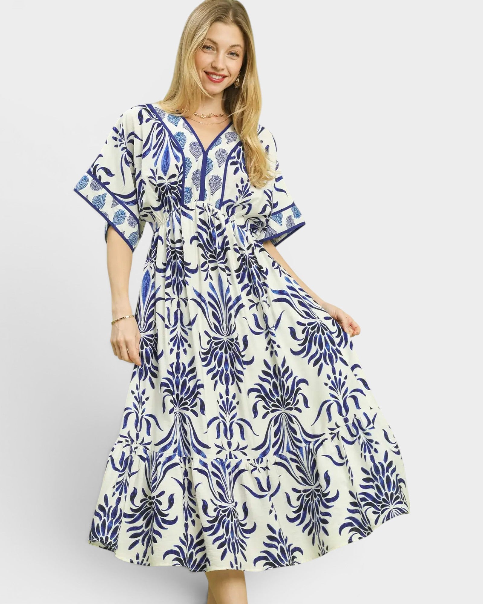 Woman wearing a blue and white patterned dress on a light gray background
