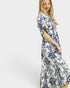 Woman wearing a blue and white patterned dress on a white background