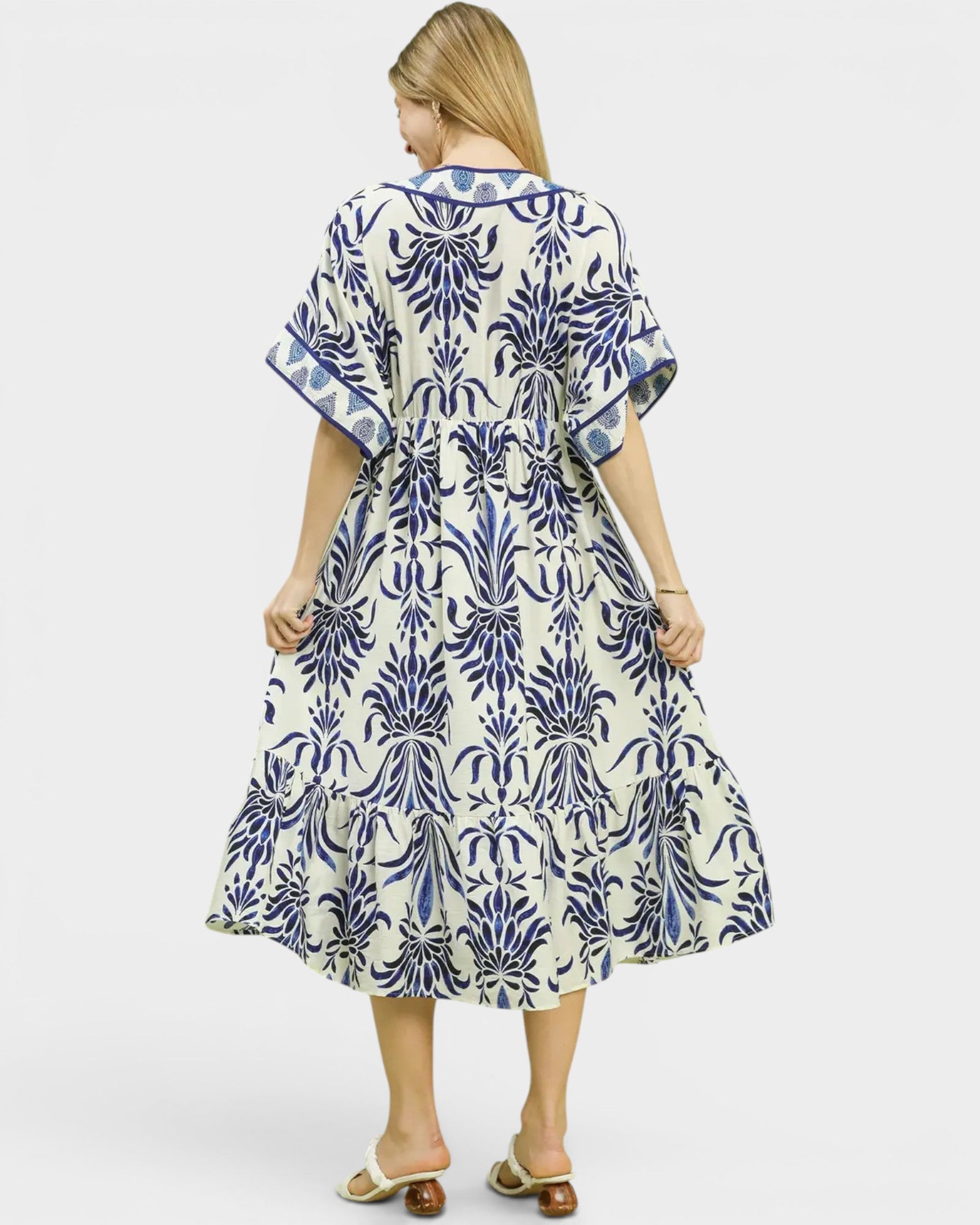 Woman wearing a blue and white patterned dress on a white background