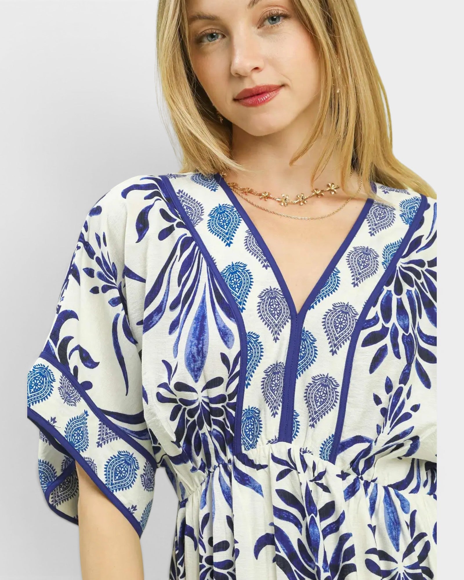 Woman wearing a blue and white patterned dress on a plain background