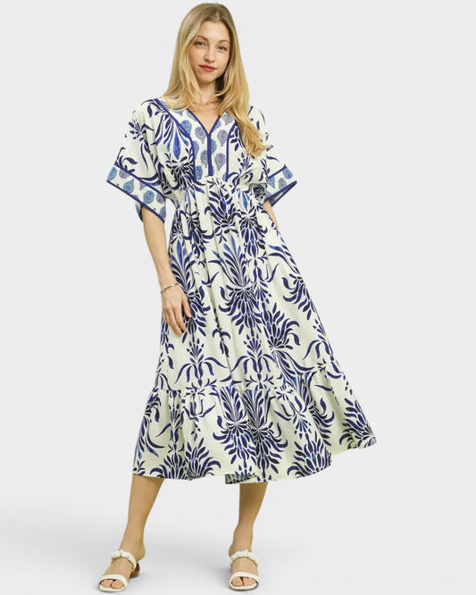 Woman wearing a blue and white patterned dress on a white background