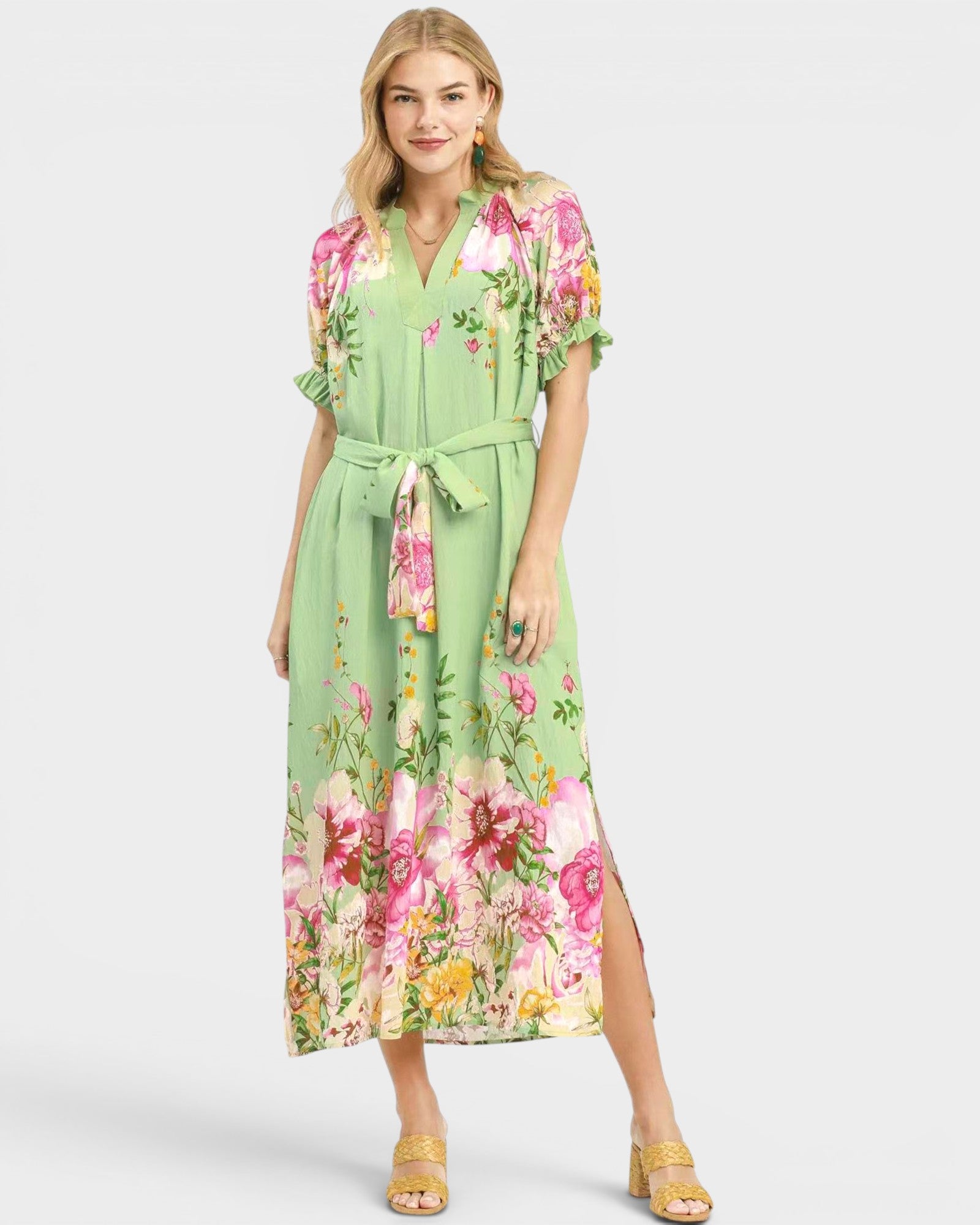 Woman wearing a green floral dress on a white background