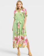 Woman wearing a green floral dress on a white background