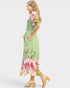 Woman wearing a green floral dress on a white background