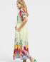 Woman wearing a colorful floral dress on a light gray background