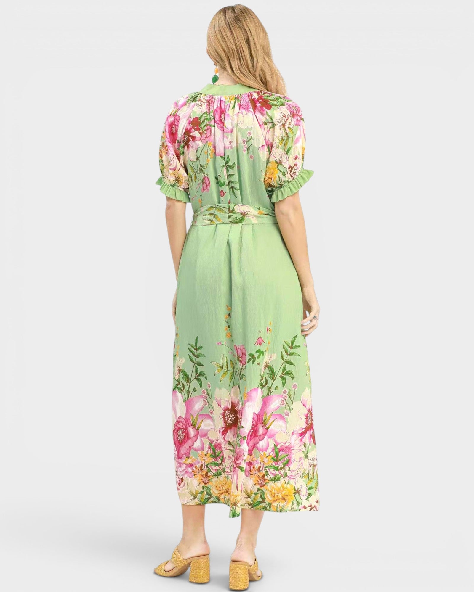 Woman wearing a green floral dress on a white background