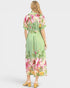 Woman wearing a green floral dress on a white background