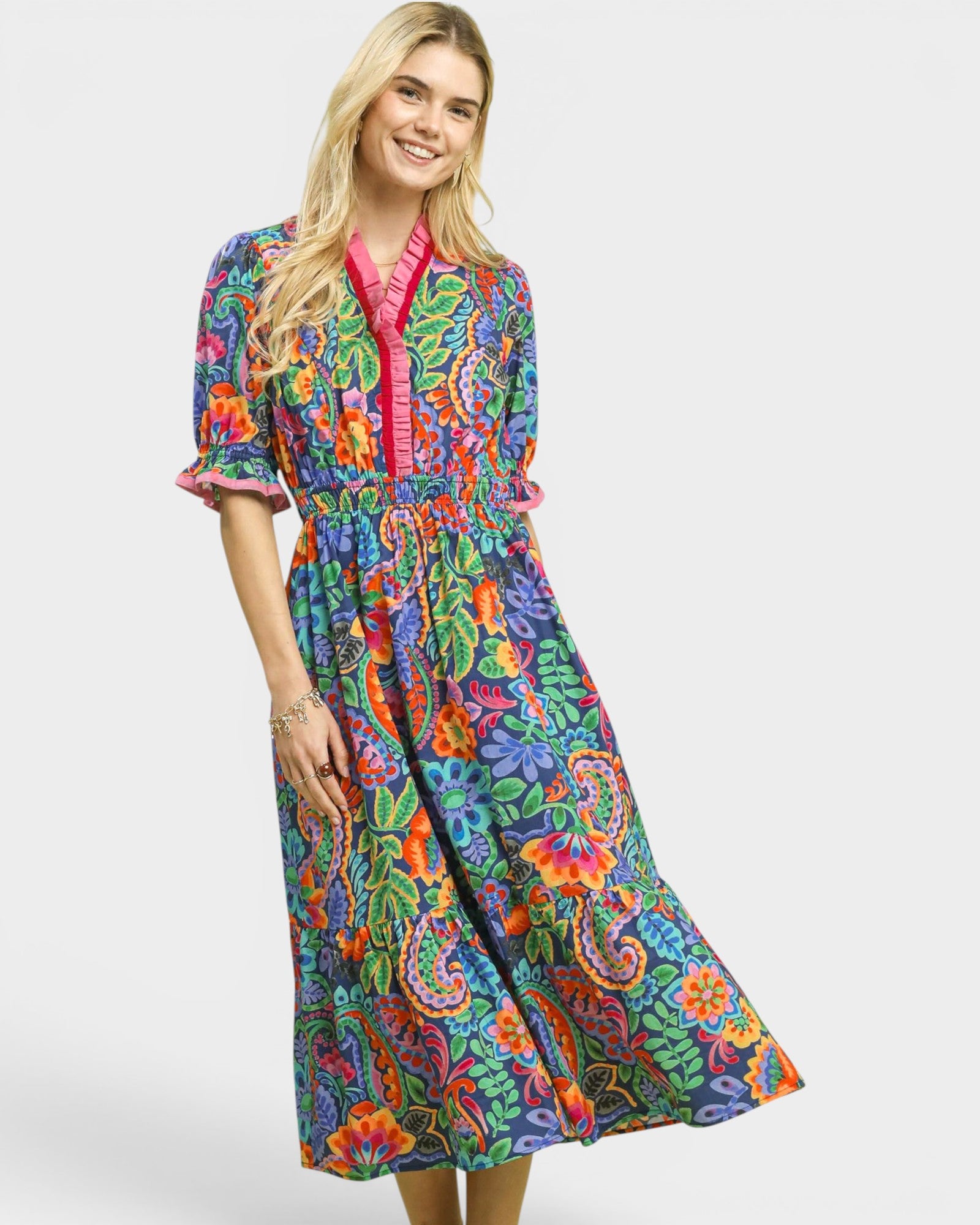 Woman wearing a colorful patterned dress on a white background