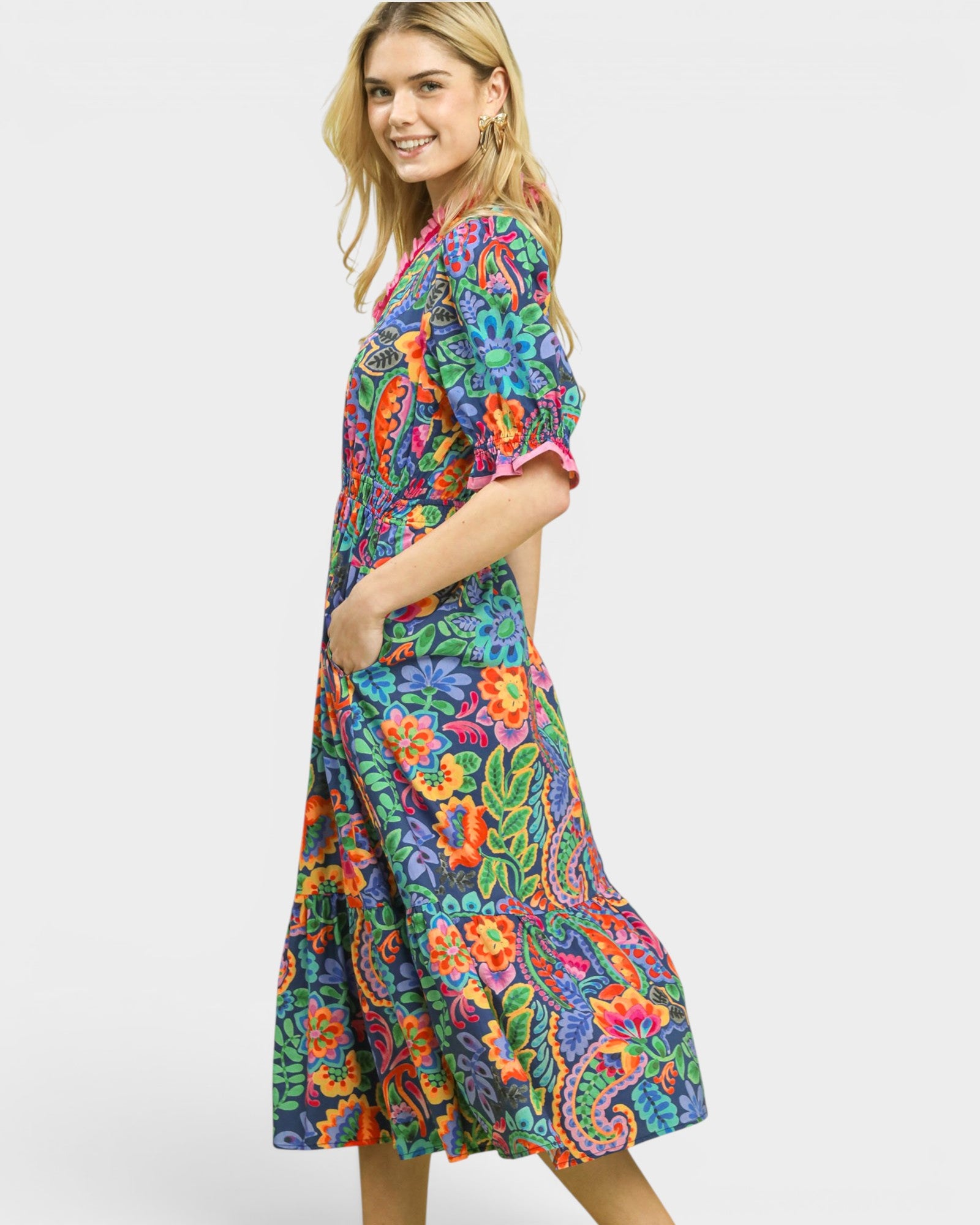 Woman wearing a colorful floral dress on a white background