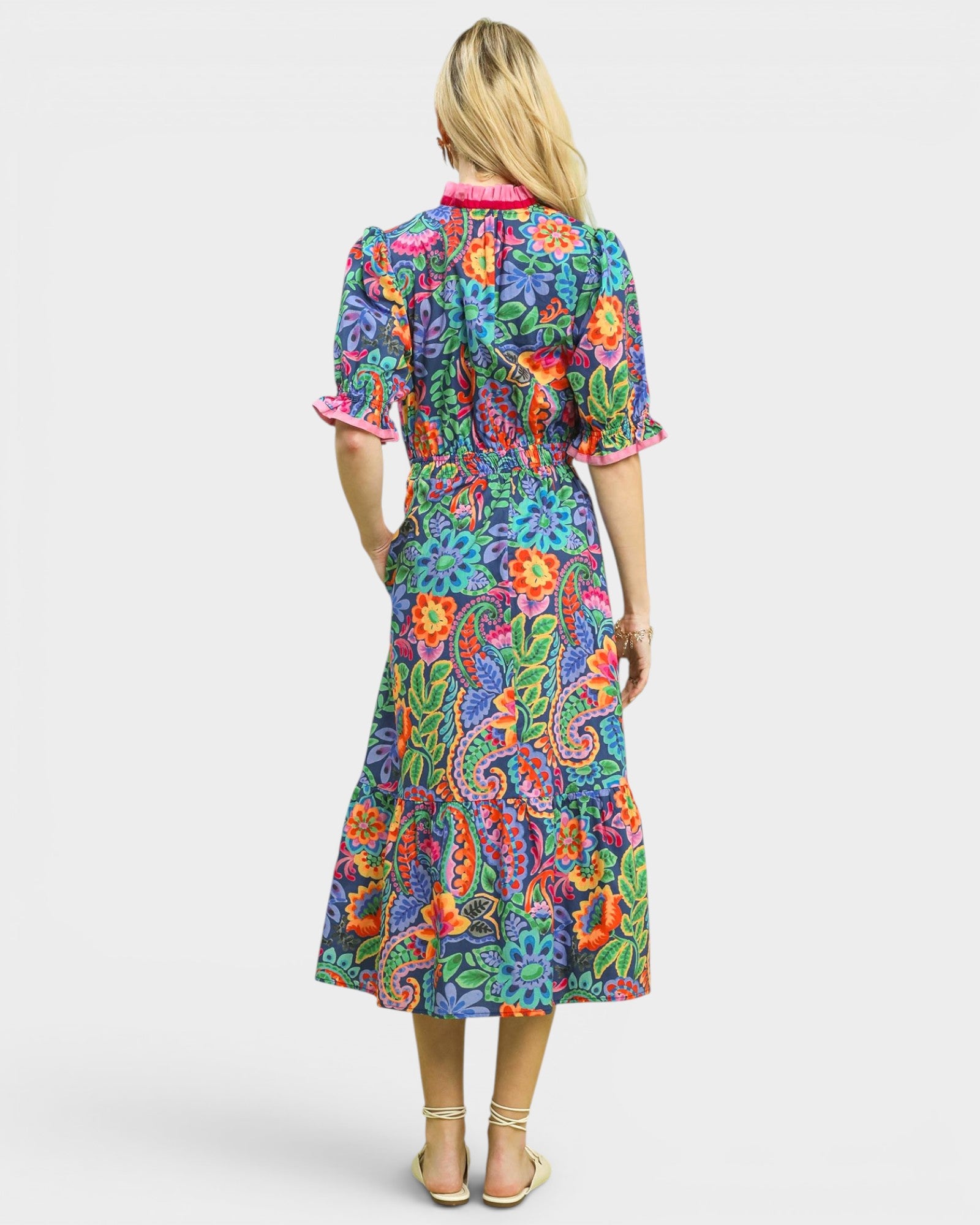 Woman wearing a colorful floral dress on a white background