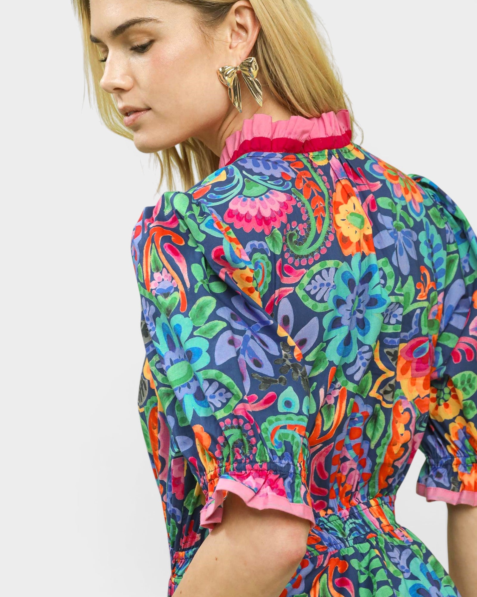 Woman wearing a colorful floral dress with a white background